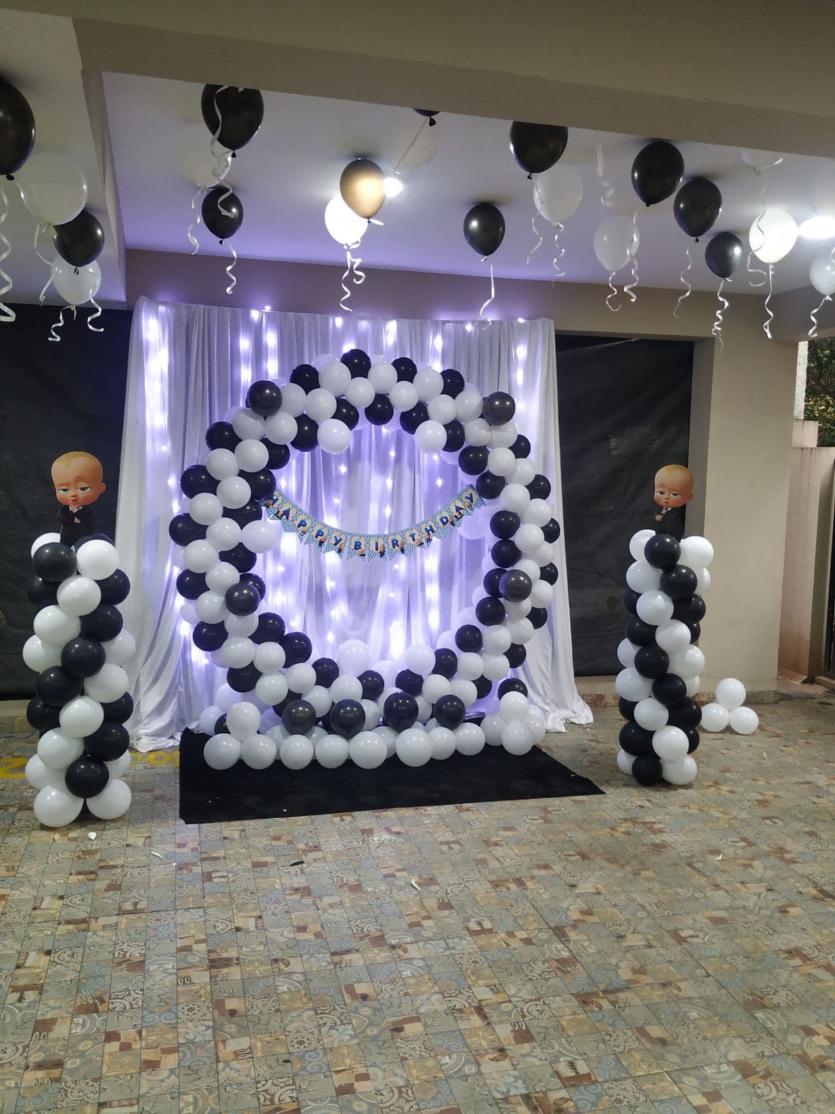 Black and white balloon ring backdrop with fairy-light curtain