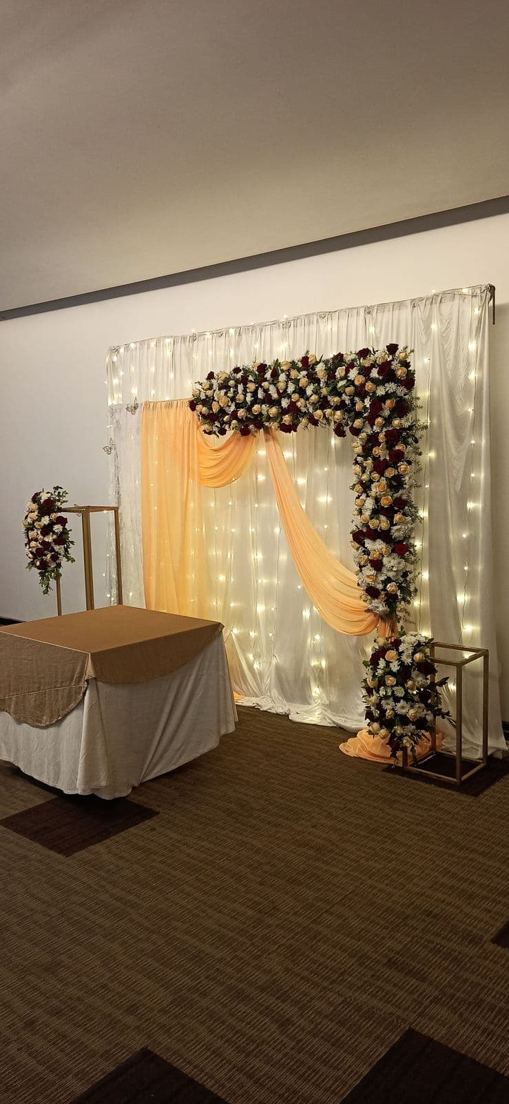 Fairy-light curtain with cascading floral corner