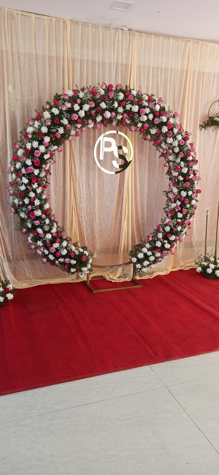 Floral ring with couple monogram at the end of a red carpet