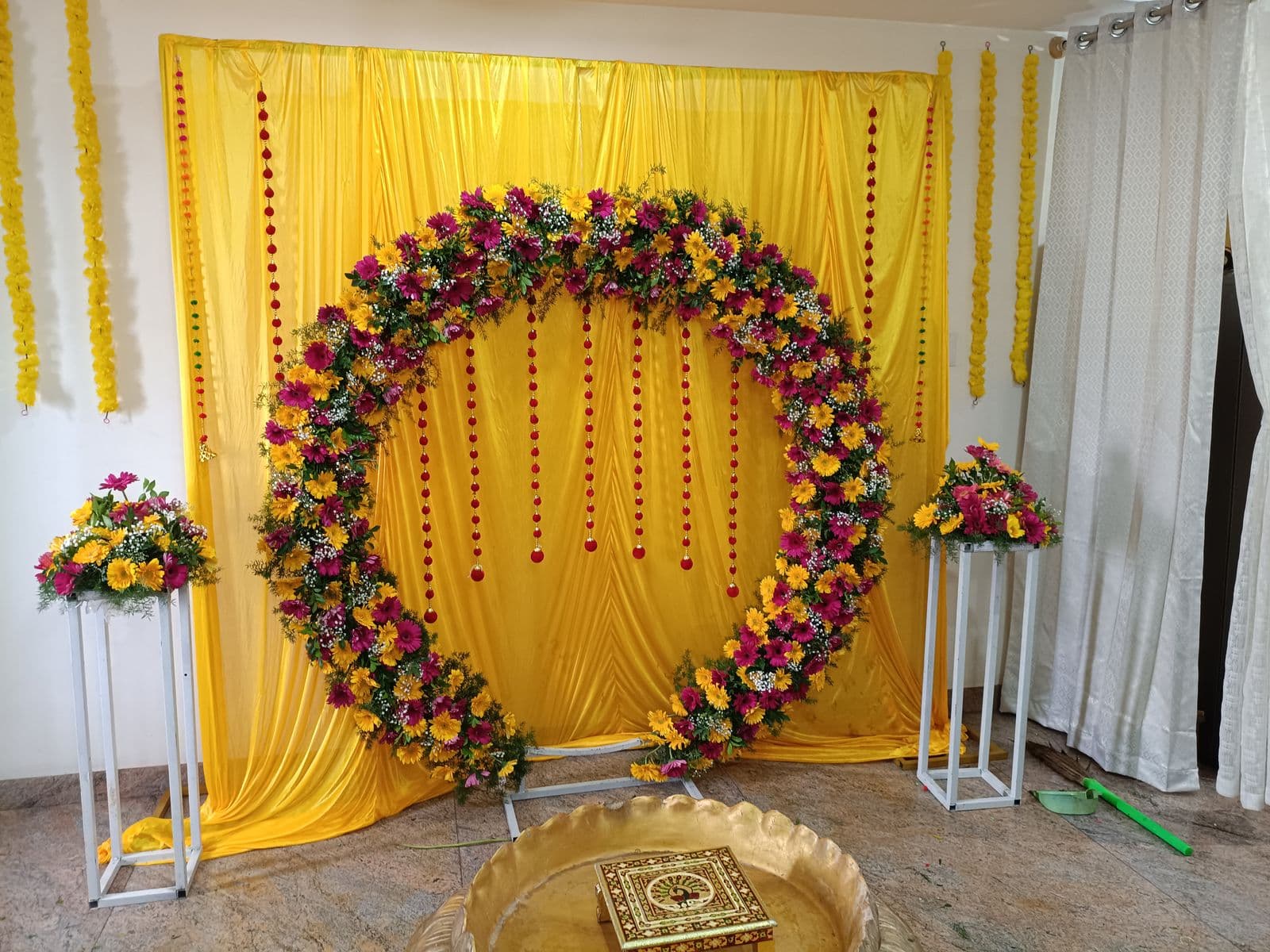 Floral ring on yellow drapes with brass urli for haldi