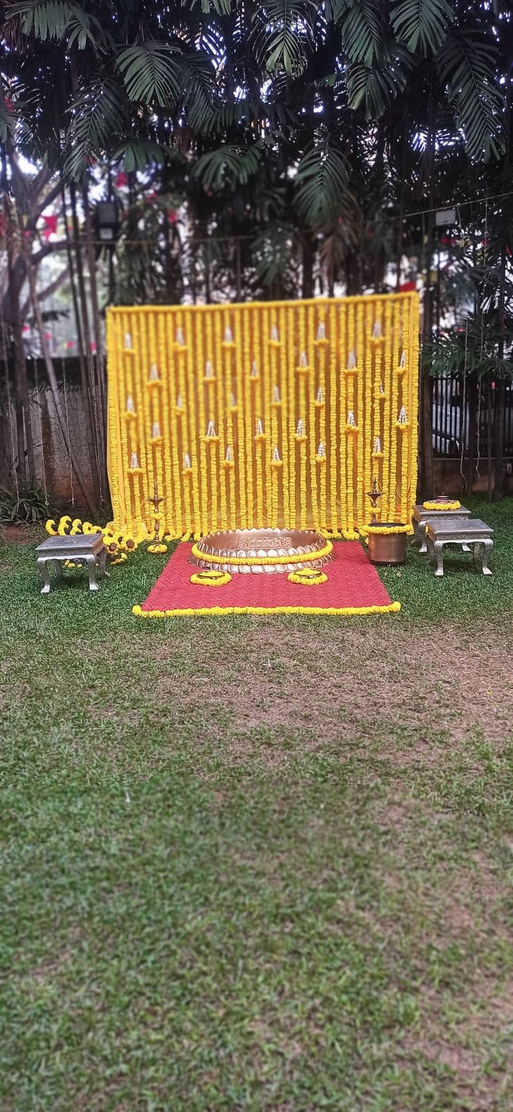 Garden haldi backdrop with a marigold wall and floor seating