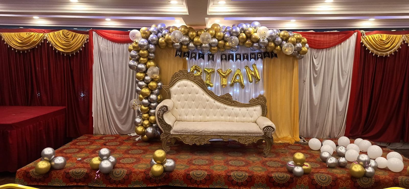 Balloon stage in gold and white with a white chaise