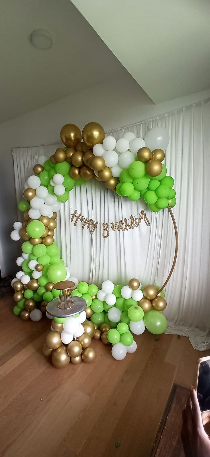 Green and gold balloon ring with neon sign for a home birthday