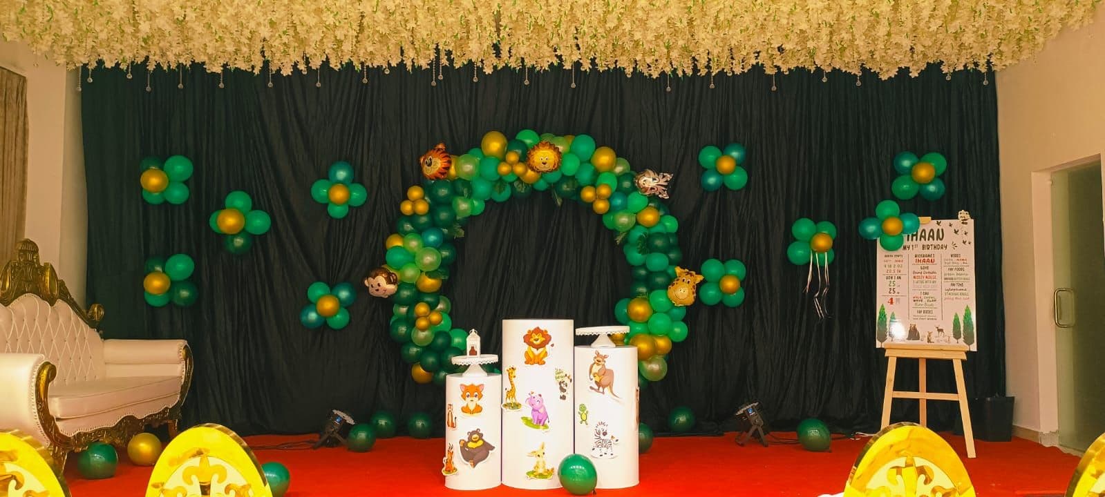 Jungle-themed balloon ring on a hall stage with green drapes