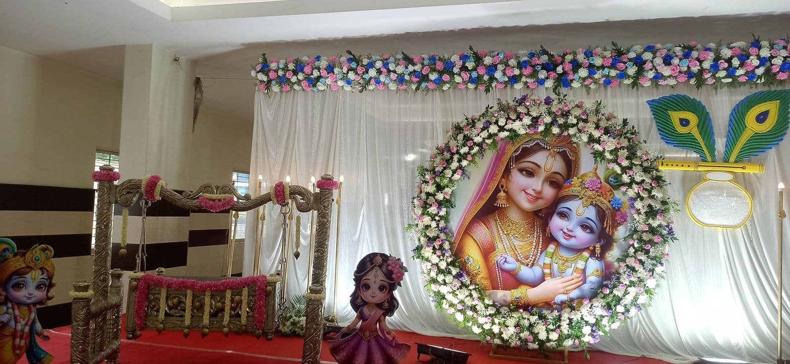 Krishna-themed floral ring backdrop for a naming ceremony