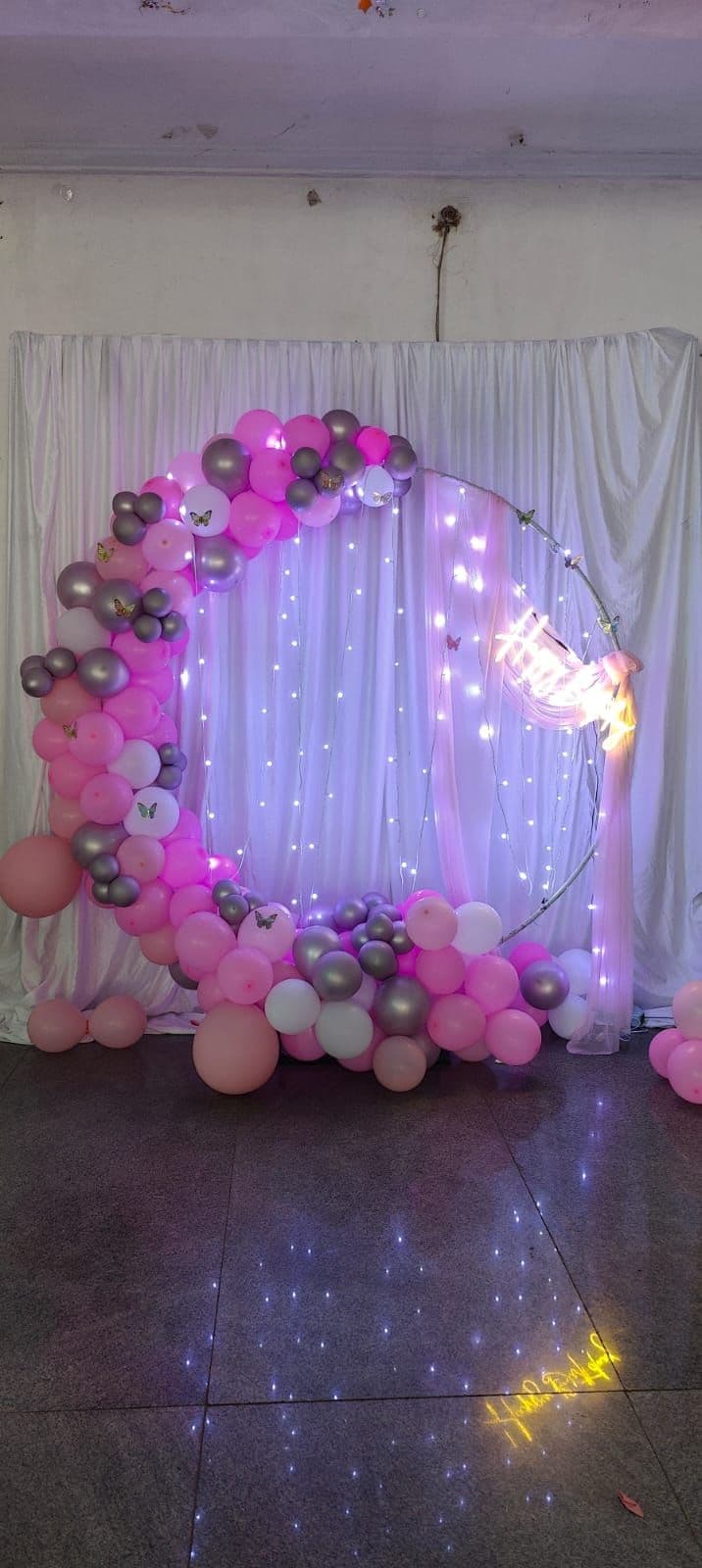 Pink and silver balloon ring with fairy-light curtain for a birthday
