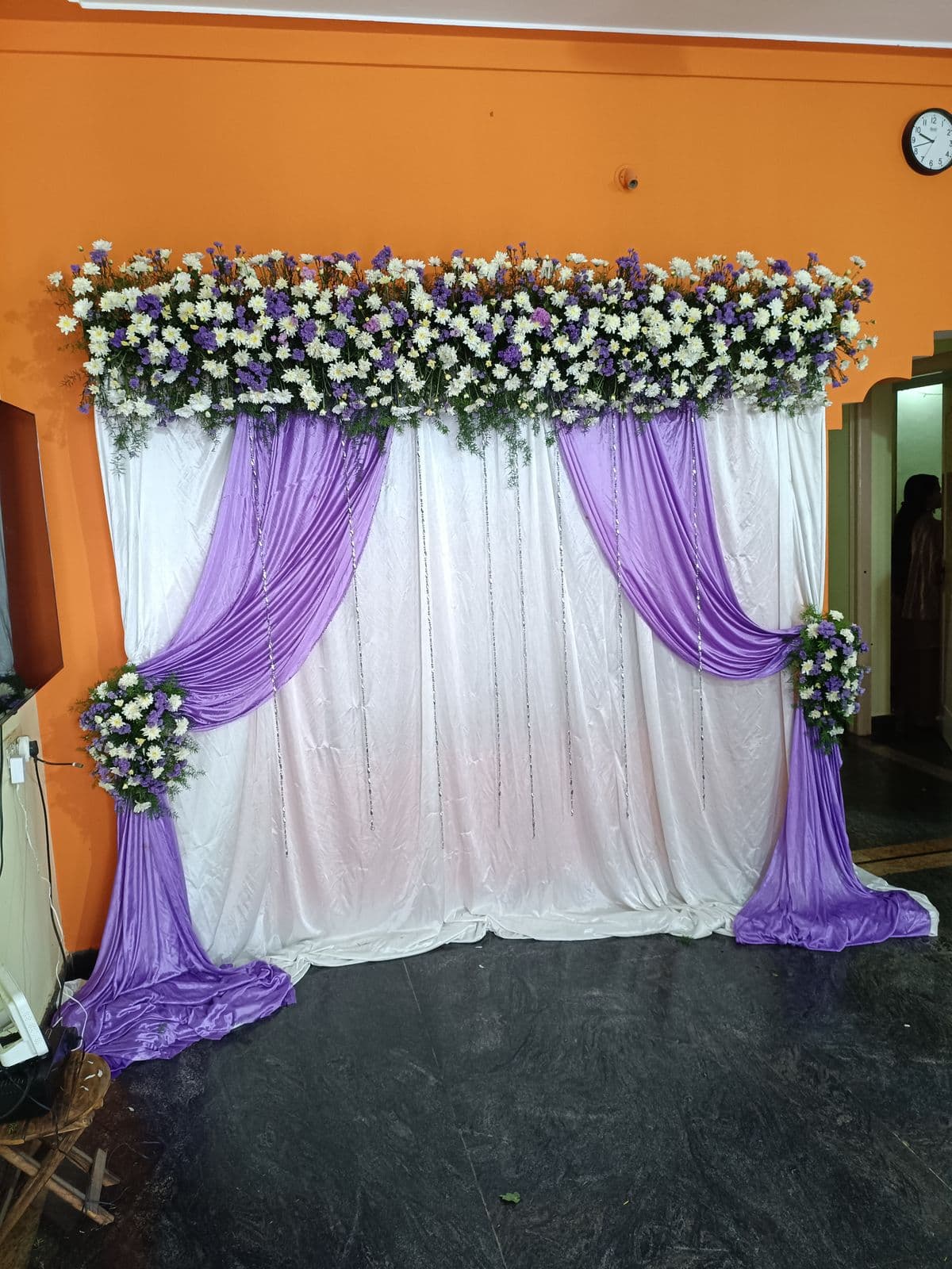 Purple and white drape backdrop with mixed flower top