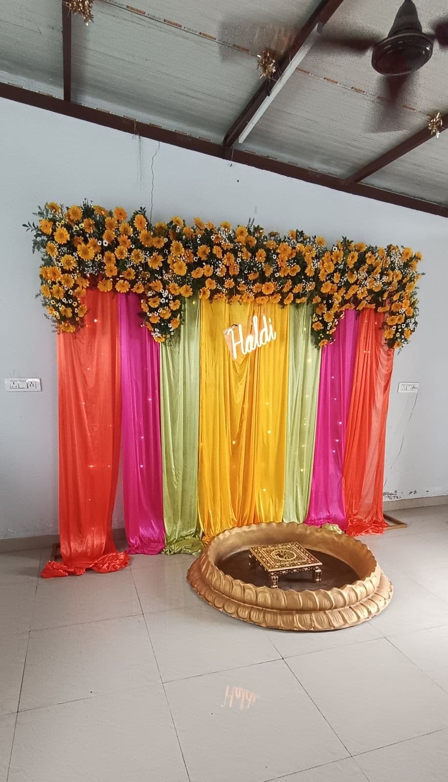 Rainbow drape haldi backdrop with sunflower top and urli