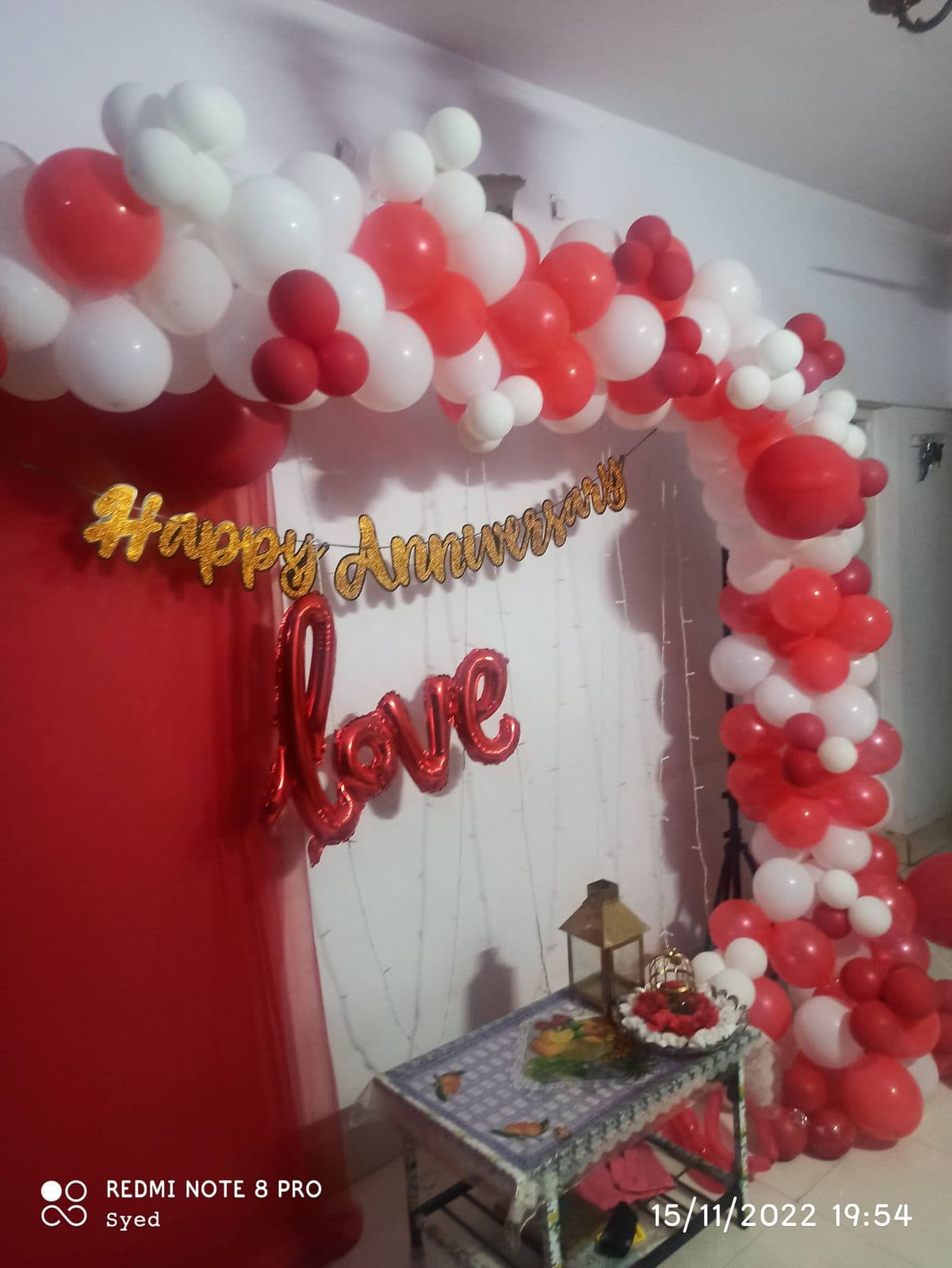 Red and white balloon arch with Happy Anniversary sign