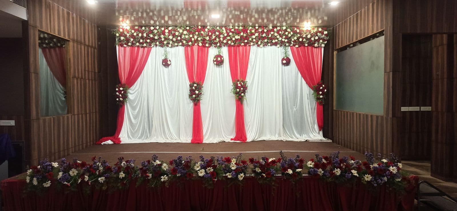 Stage with red and white drapes and a rose border