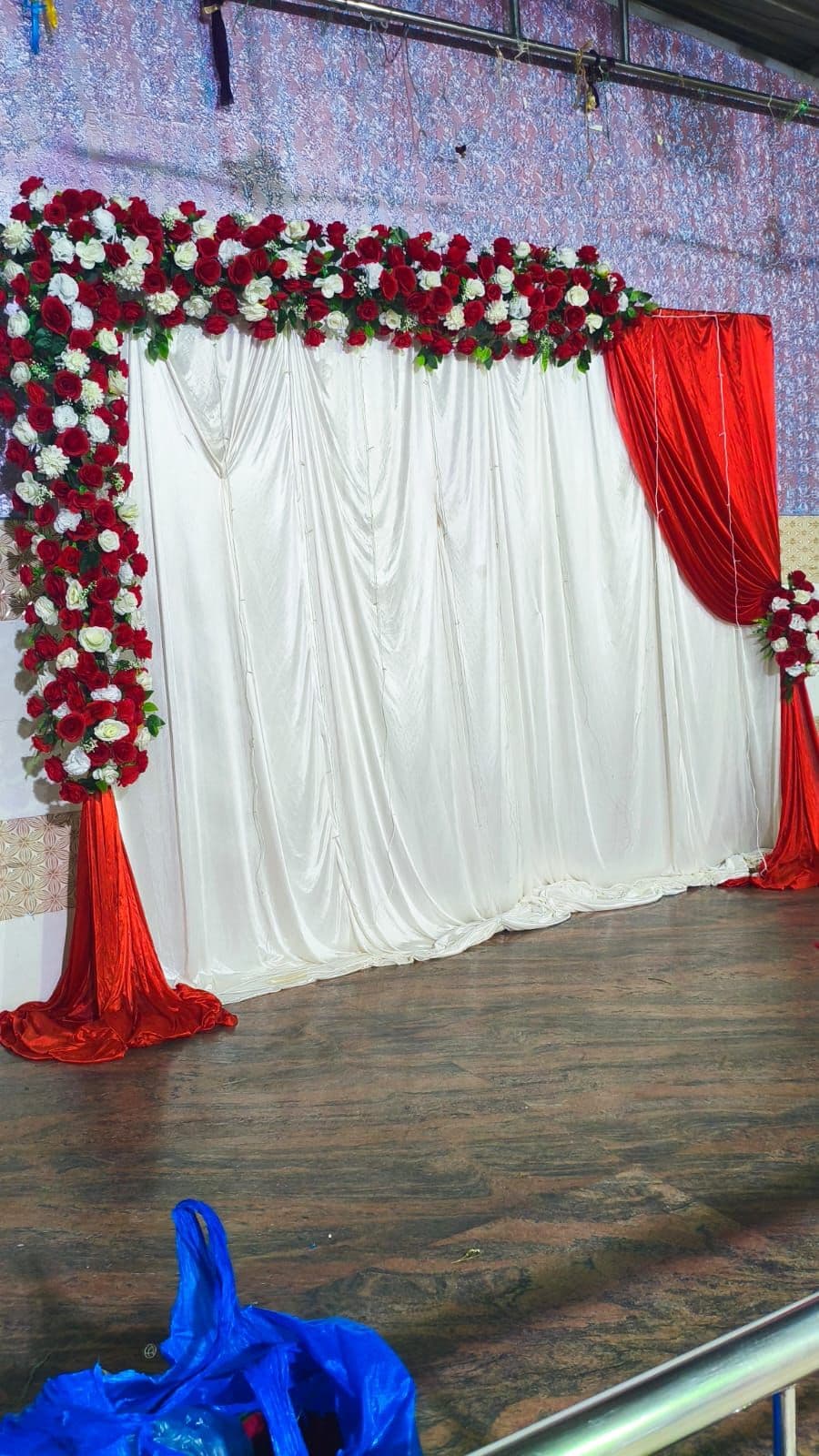 Red and white drape backdrop with rose corner