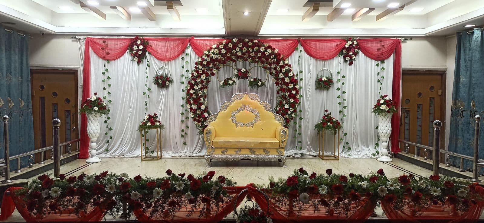 Red and white stage with floral ring and gold sofa