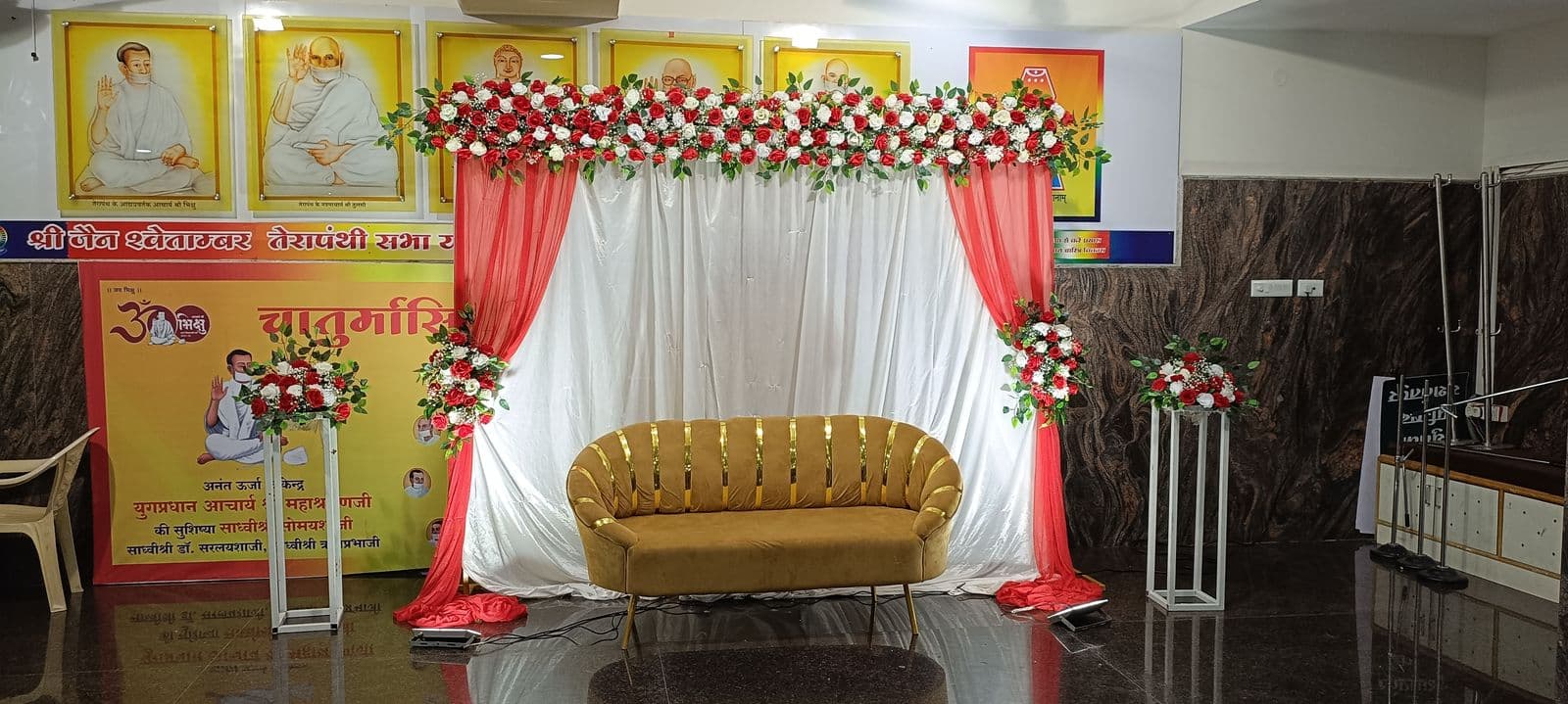 Red and white floral stage in a community hall