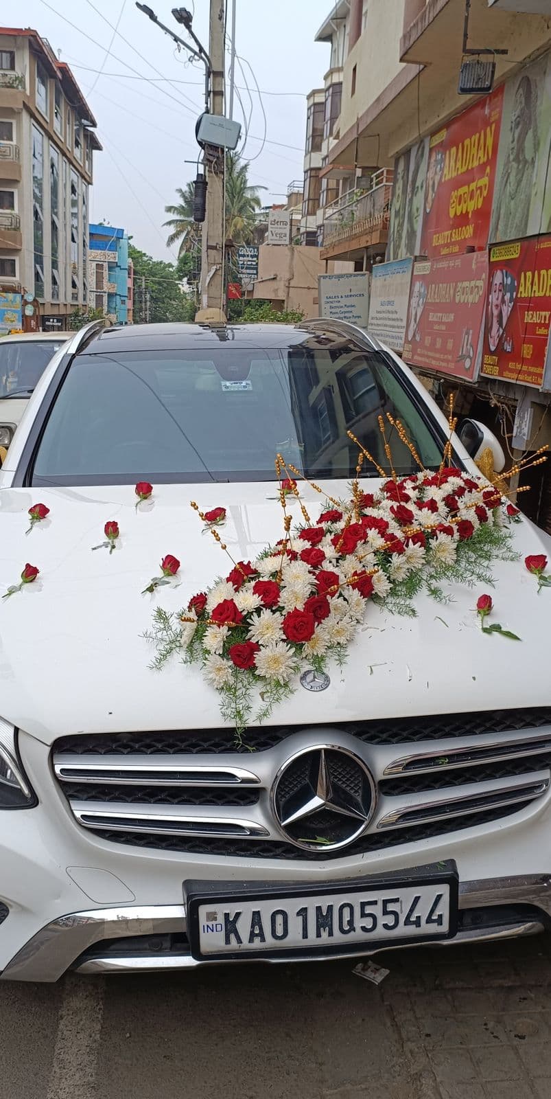 Red and white rose arrangement across the bonnet of a white Mercedes