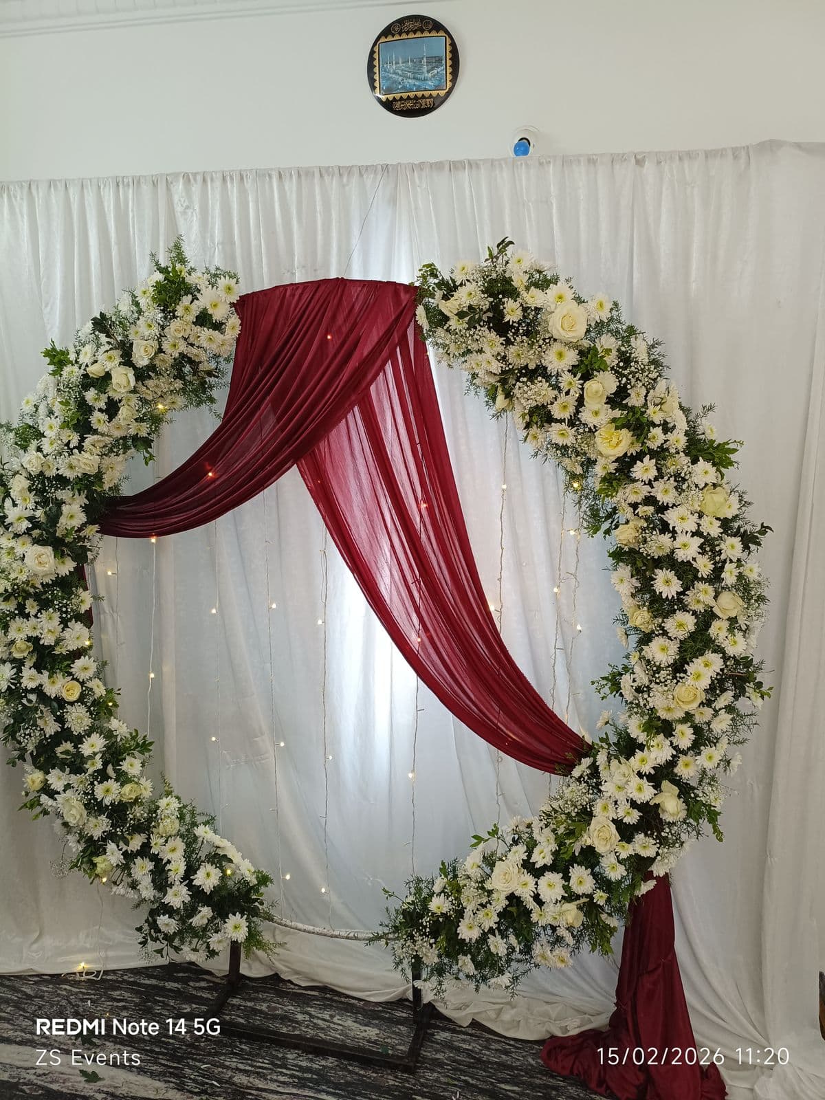 White rose floral ring with maroon drape swag for an engagement