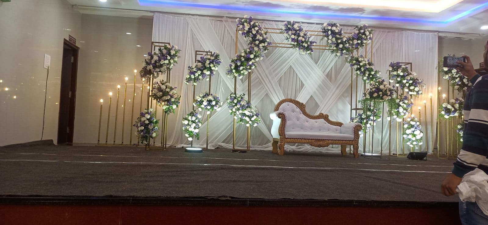 White stage with floral pillars and a white chaise
