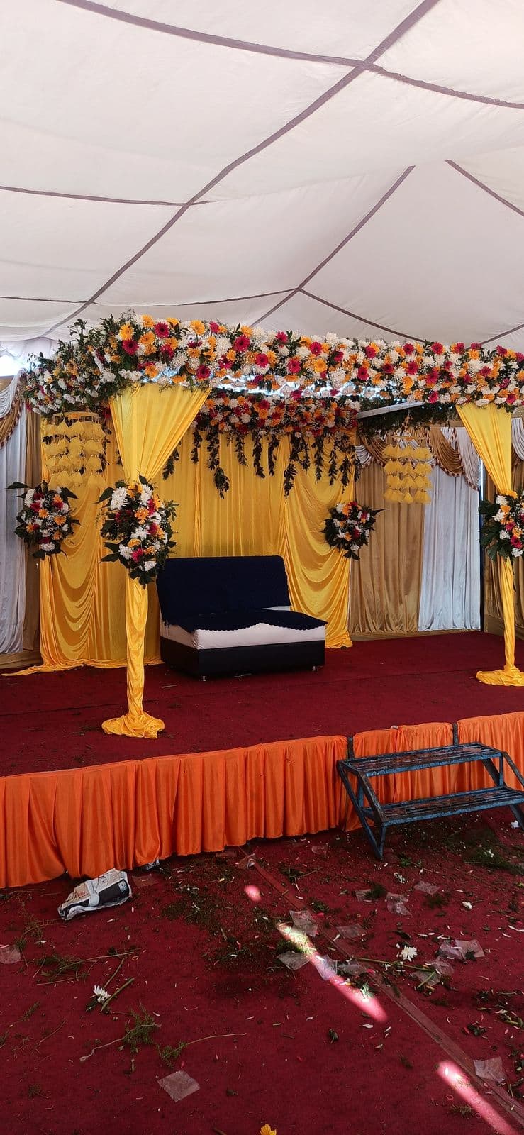 Yellow haldi stage under a tent with floral canopy