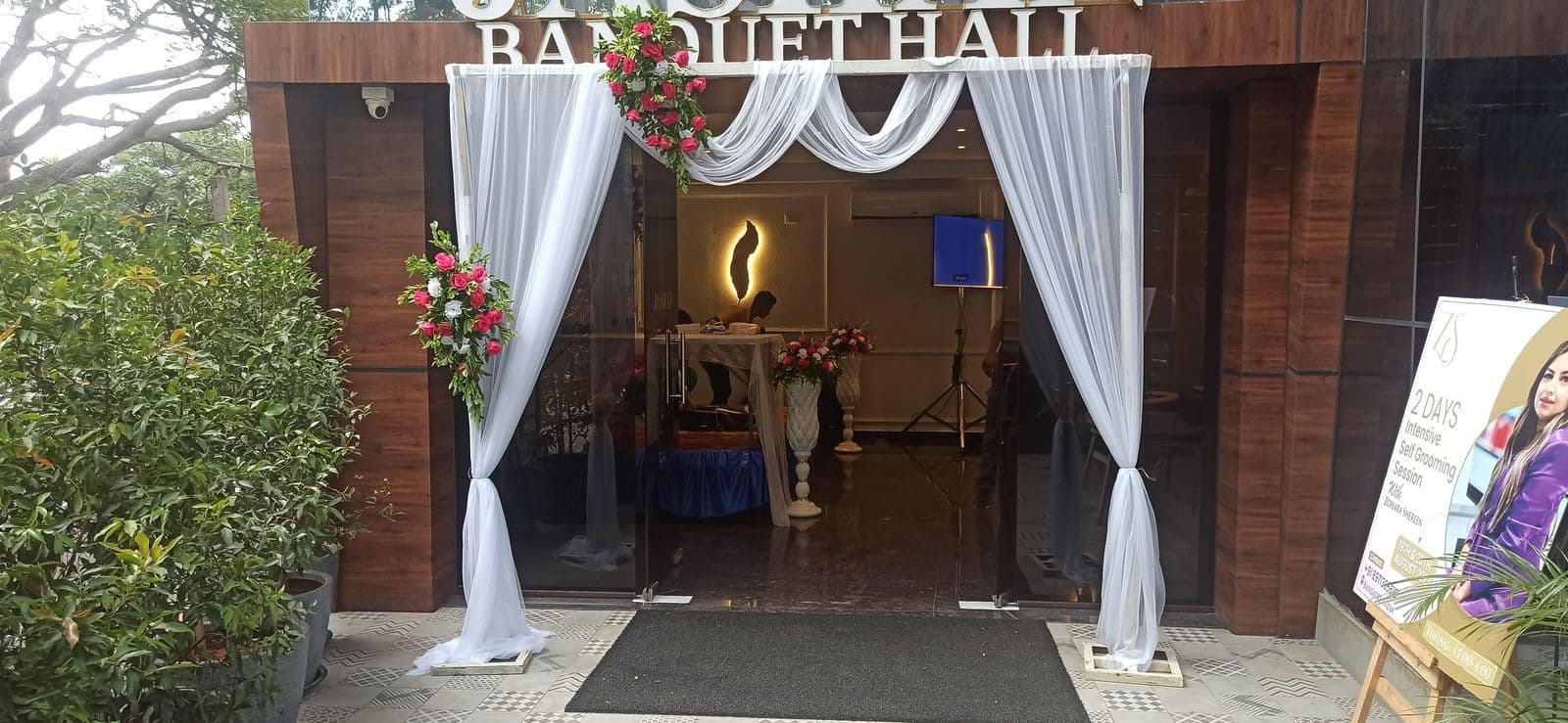 Banquet hall entrance with white drapes and florals