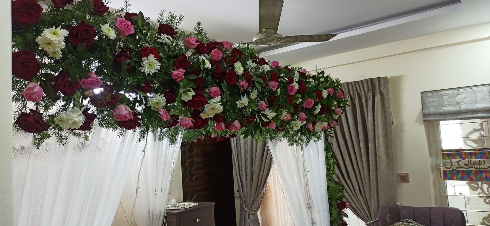Floral canopy with white drapes over a home entrance