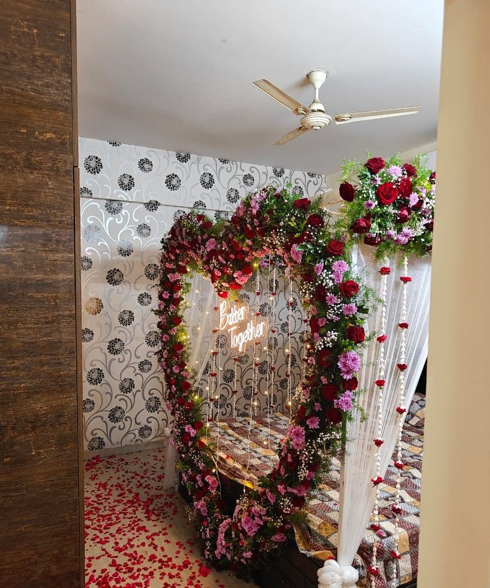 Floral heart arch and rose petals for a room surprise