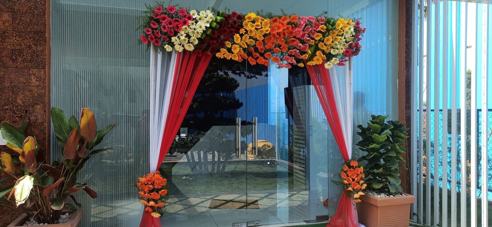 Glass entrance framed with red and orange florals