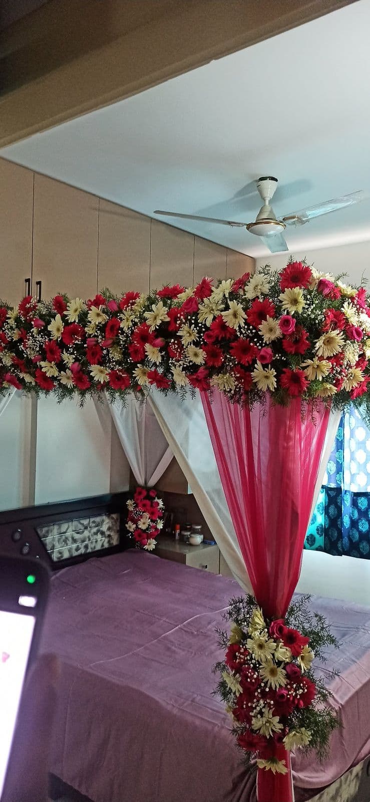 Bed canopy decorated with red and white roses